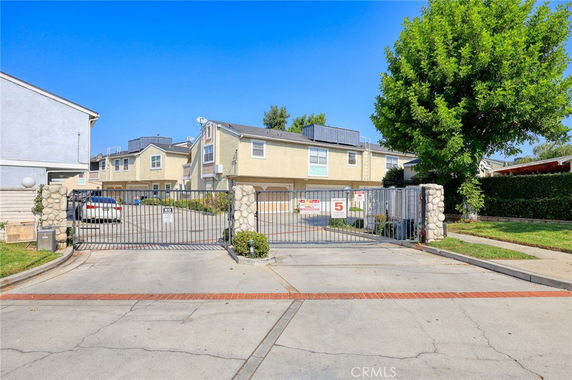 Front view of a gated residential building with two stories and multiple units.