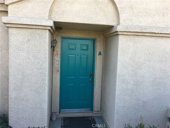 Front view of a house entrance with a teal door and small porch.