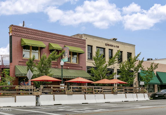 Front view of commercial buildings with awnings and outdoor seating