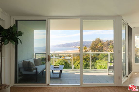 Panoramic view of the coastline and hills from a balcony.