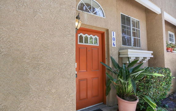 Front view of a house with a distinctive orange door.