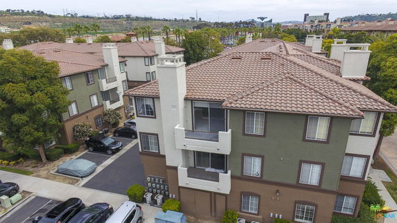 Front view of a multi-story apartment building with balconies and chimneys.