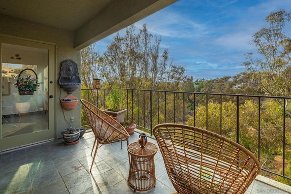 Balcony view overlooking trees and distant landscape.