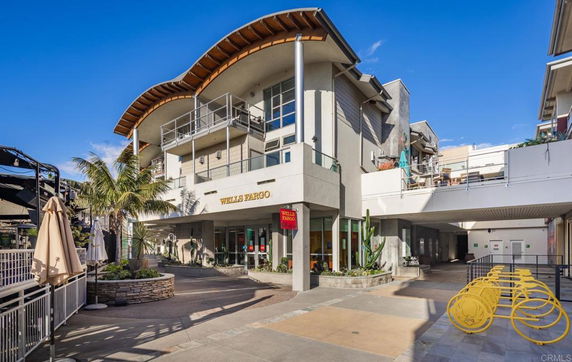 Front view of a multi-story building with a modern design and outdoor walkway.