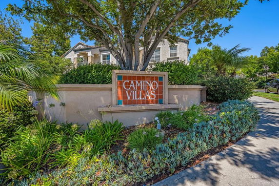 Front view of a multi-story building partially visible behind a sign that reads 'Camino Villas.'