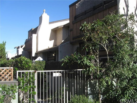 Front view of a multi-story building with a fenced entrance.