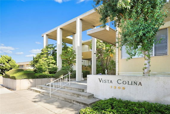 Front view of a modern building with a prominent entrance featuring large columns and steps, labeled 'Vista Colina'.