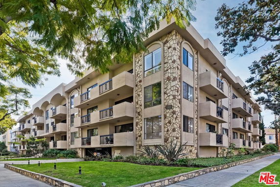 Front view of a multi-story apartment building with balconies.
