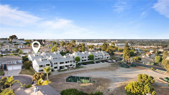 Aerial view of a residential area with multiple houses and surrounding landscape.