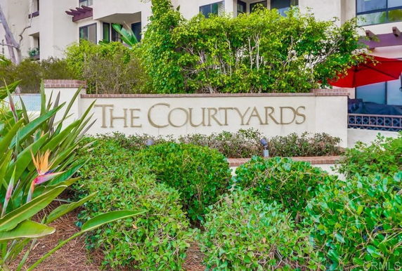 Front view of a residential building with a sign reading 'The Courtyards.'