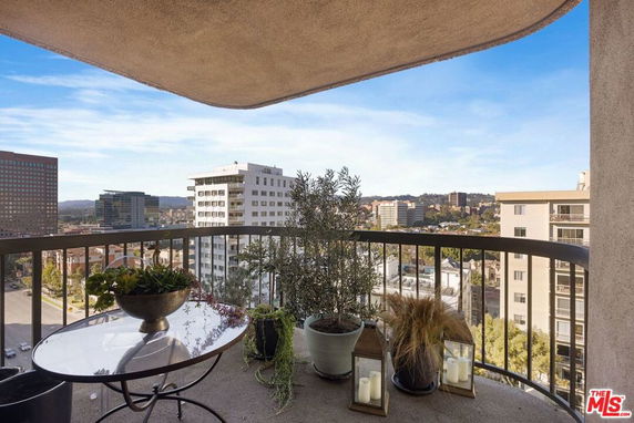 Balcony view overlooking a cityscape with buildings and a distant horizon.