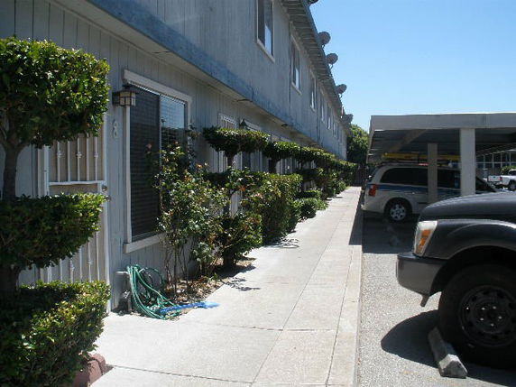 Outdoor parking area next to a row of buildings.