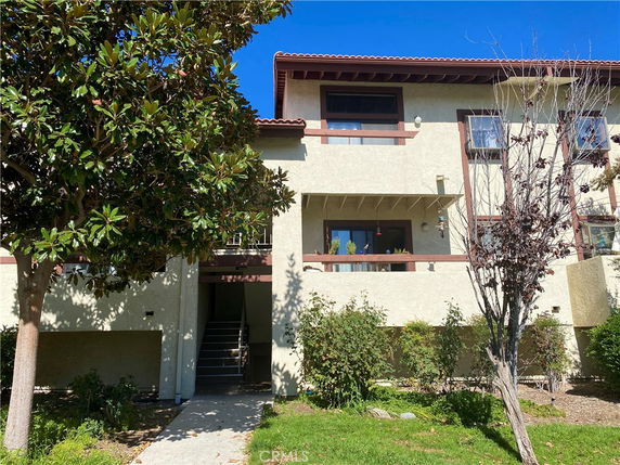 Front view of a two-story residential building with a beige exterior and brown trim.