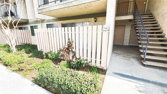 Exterior view of a multi-story building with an entrance and staircase.