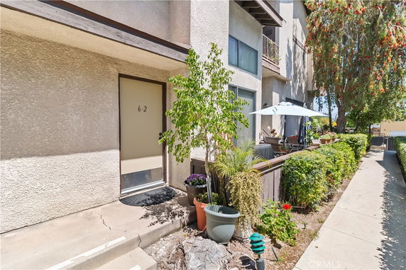 Front view of a multi-story residential building with patio area.