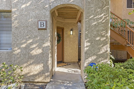Entrance view of a residential building with an archway and stairs.