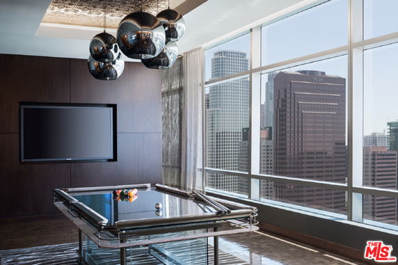 Indoor recreation area with a pool table and large windows offering a city view.