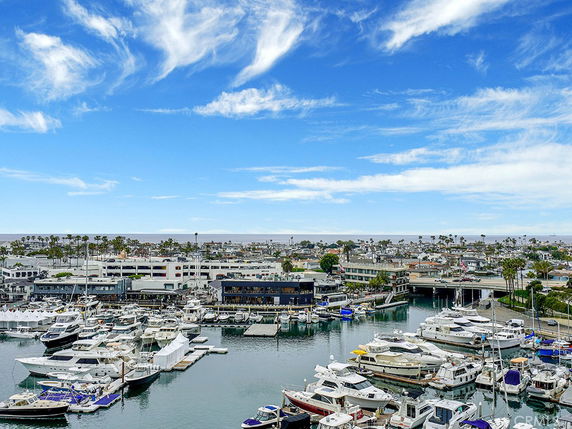 Panoramic view of a marina with multiple boats and a coastal area in the background.