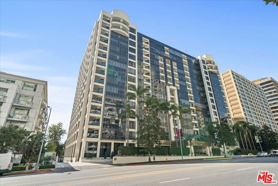 Front view of a multi-story residential building with large glass windows.
