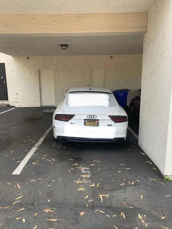 Covered parking area with a white car parked.