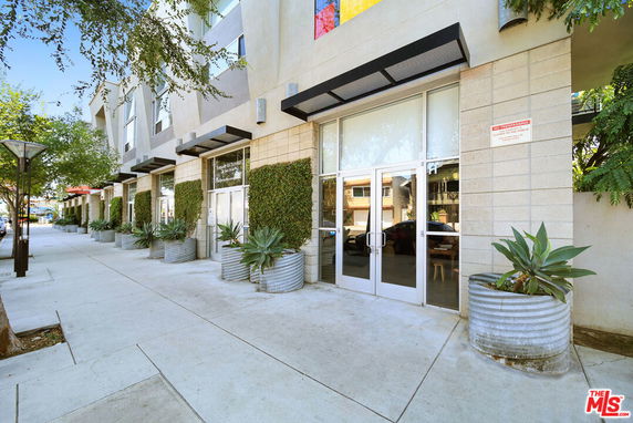 Front view of a building with large glass doors and planters.