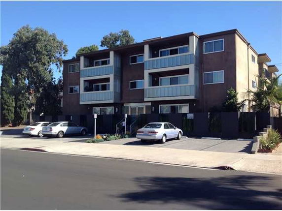 Front view of a three-story apartment building with balconies.