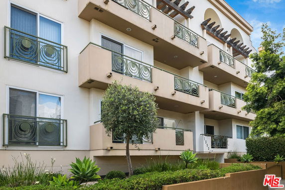 Front view of a multi-story apartment building with balconies.