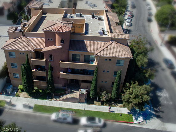Front view of a multi-story building with a terracotta tile roof and balconies.