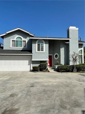Front view of a two-story house with a garage and chimney.