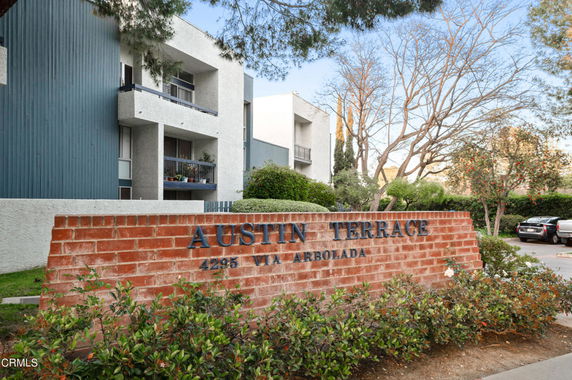 Front view of a multi-story residential building with a brick wall labeled Austin Terrace.