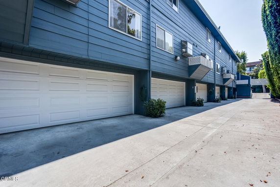 Outdoor parking area with multiple garage doors in a residential building.