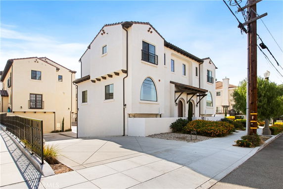 Front view of a two-story house with arched windows and a driveway.
