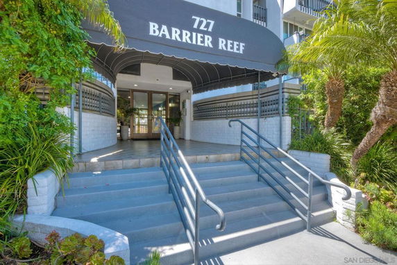 Front view of a building entrance with steps leading to the doorway, covered by a canopy.