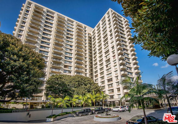 Front view of tall apartment building with multiple balconies.