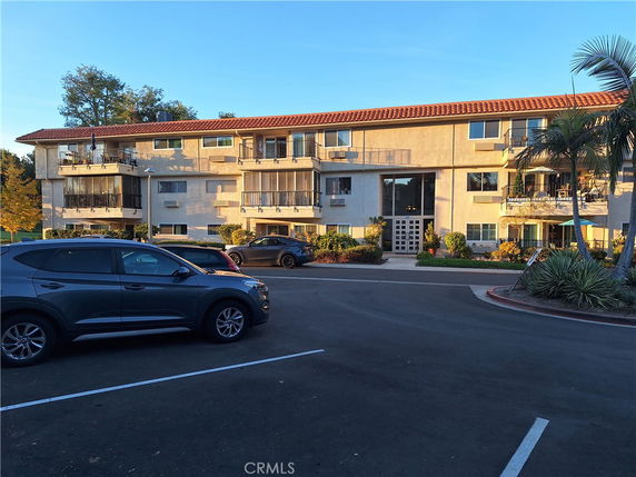 Front view of a three-story apartment building with balconies.