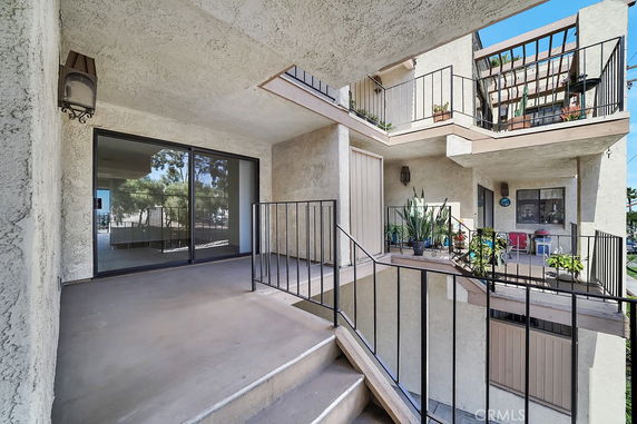 Exterior view of a residential building with balconies and stairways.