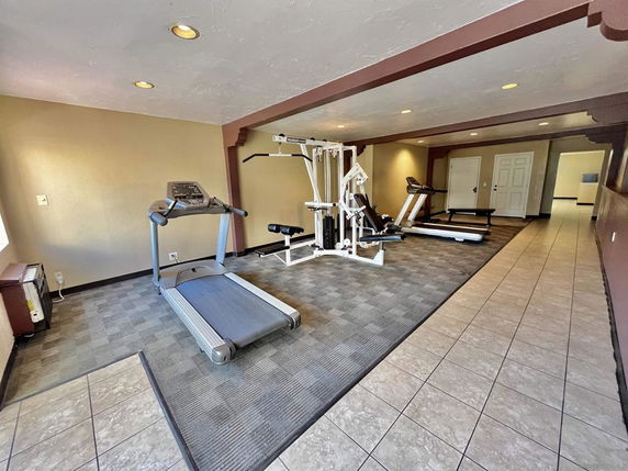 Indoor gym area with exercise equipment including treadmills and a weight machine.
