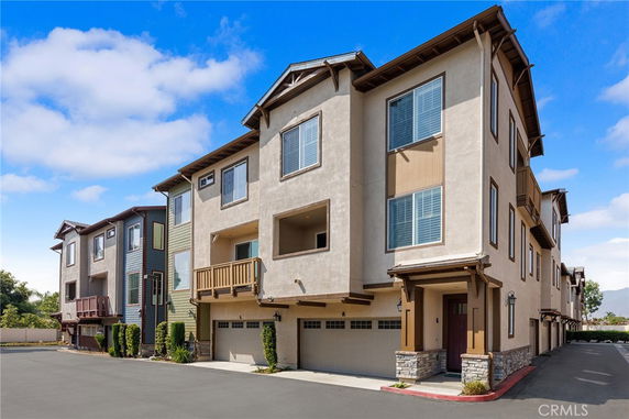 Front view of a multi-story townhouse with a double garage.