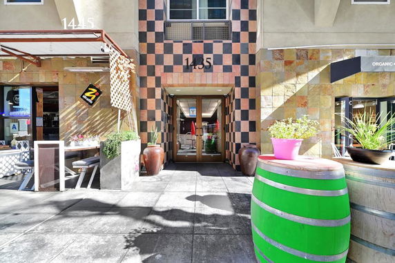 Front view of a building with a checkered entrance and outdoor seating area.