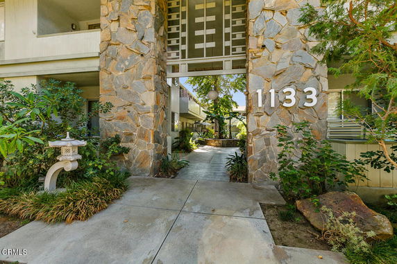 Front view of a building with a stone exterior and address number 1133.