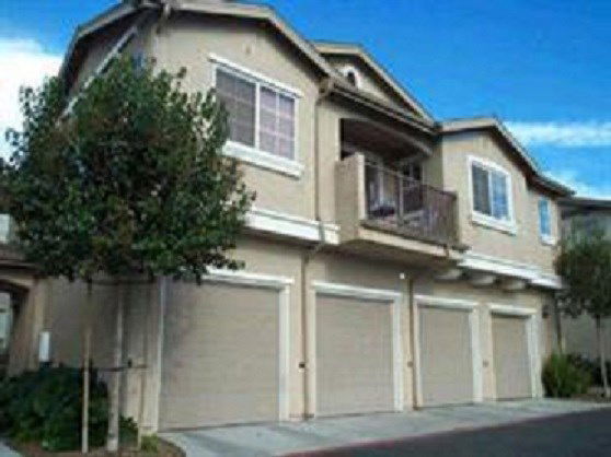 Front view of a two-story house with multiple garages and a small balcony.