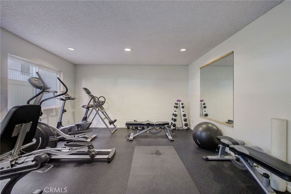 Indoor gym area with exercise equipment and a large mirror on the wall.