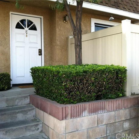 Front view of a house with a white door and small entrance steps.