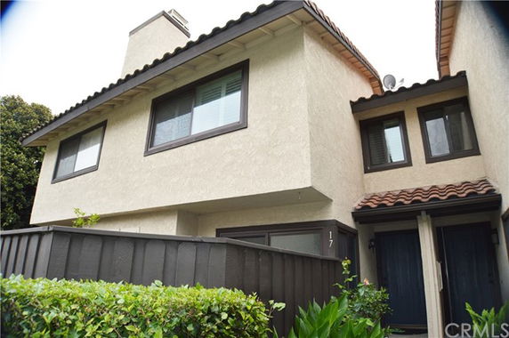 Front view of a two-story house with a beige exterior and tile roof.