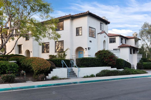 Front view of a two-story house with a stucco exterior and tile roof.