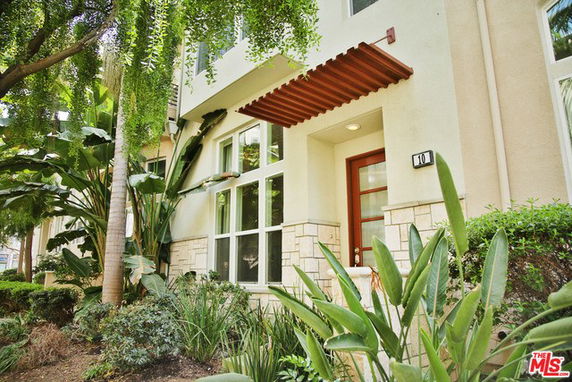 Front view of a modern two-story house with large windows and a wooden awning.