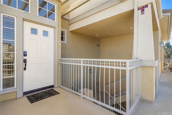 Front view of a house entryway with stairs and railing leading to the door.