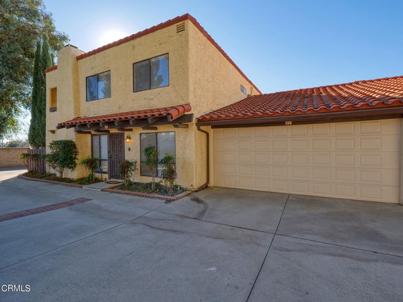 Front view of a two-story house with a double garage and red tiled roof.