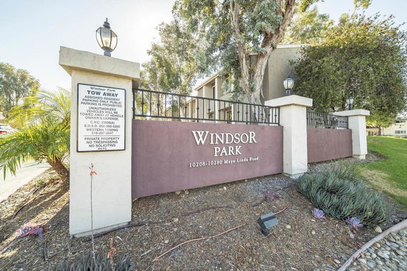 Front view of a residential building with a sign for Windsor Park and entry details.