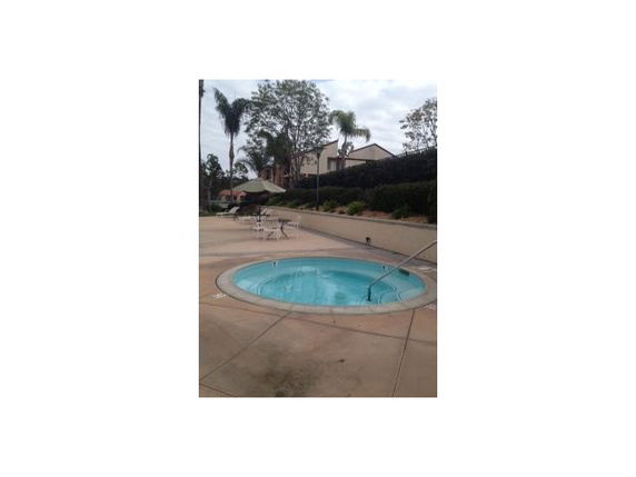 Outdoor pool area with a small round pool and surrounding patio.